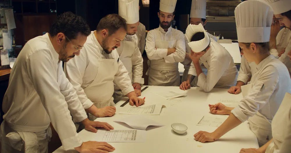 Gourmet huddle: Cesar Troigros and his kitchen team ponder the challenges of a recipe in Frederick Wiseman's "Menus-Plaisirs-Les Troigros." / Film still courtesy of Zipporah Films, Inc.