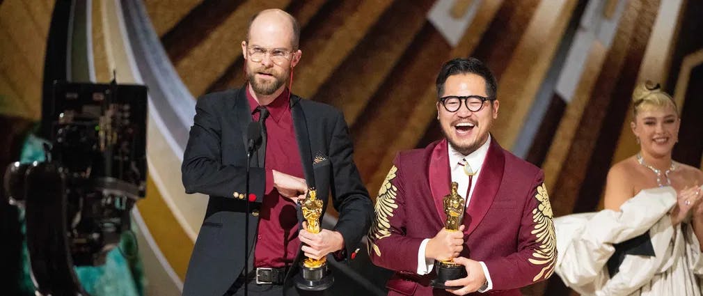 The Daniels and the Oscars: Scheinert and Kwan get their Best Original Screenplay prizes, as Florence Pugh looks on. / Photo by  Blaine Ohigashi, courtesy of ©A.M.P.A.S.